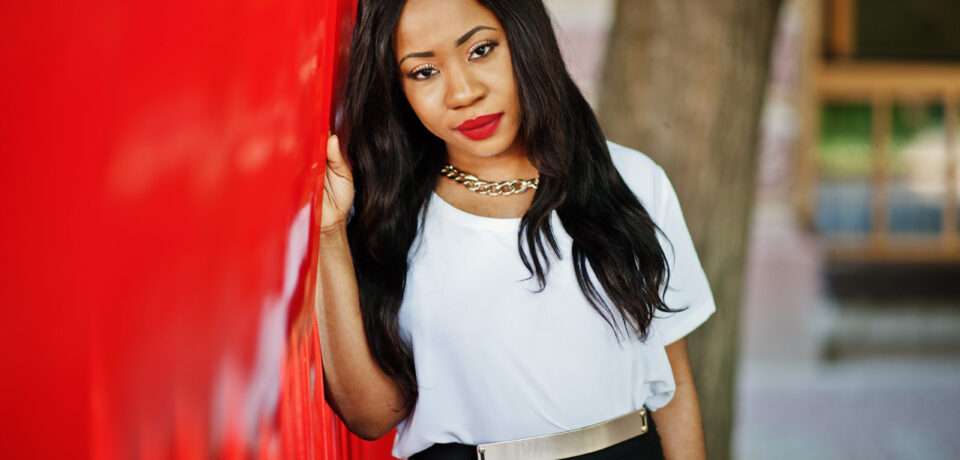 Stylish african american business woman with handbag on streets of city.