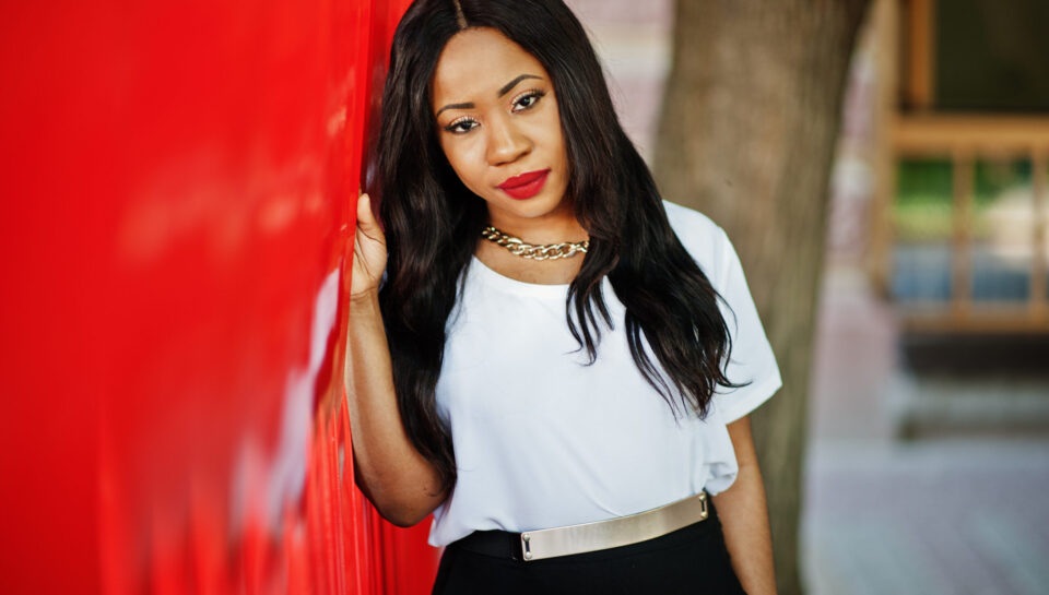 Stylish african american business woman with handbag on streets of city.